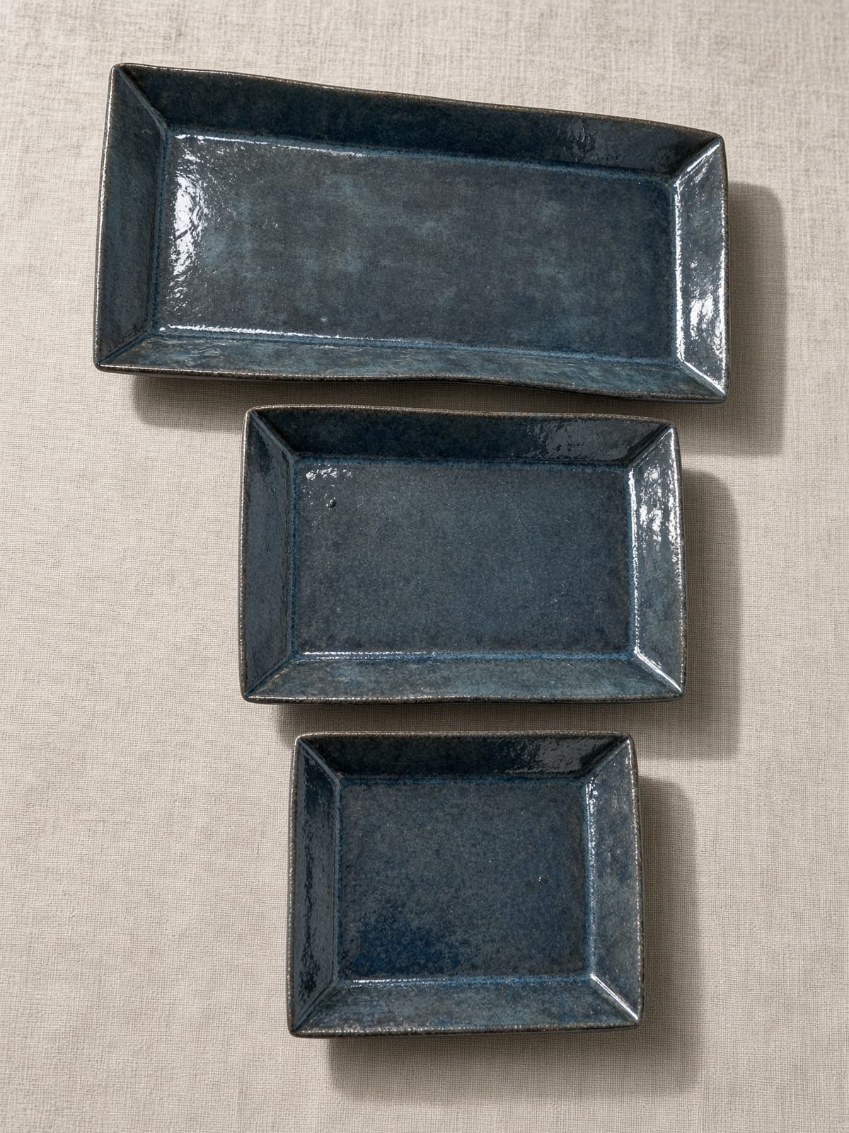 Três pratos japoneses retangulares de cerâmica em esmalte azul, tamanhos diferentes