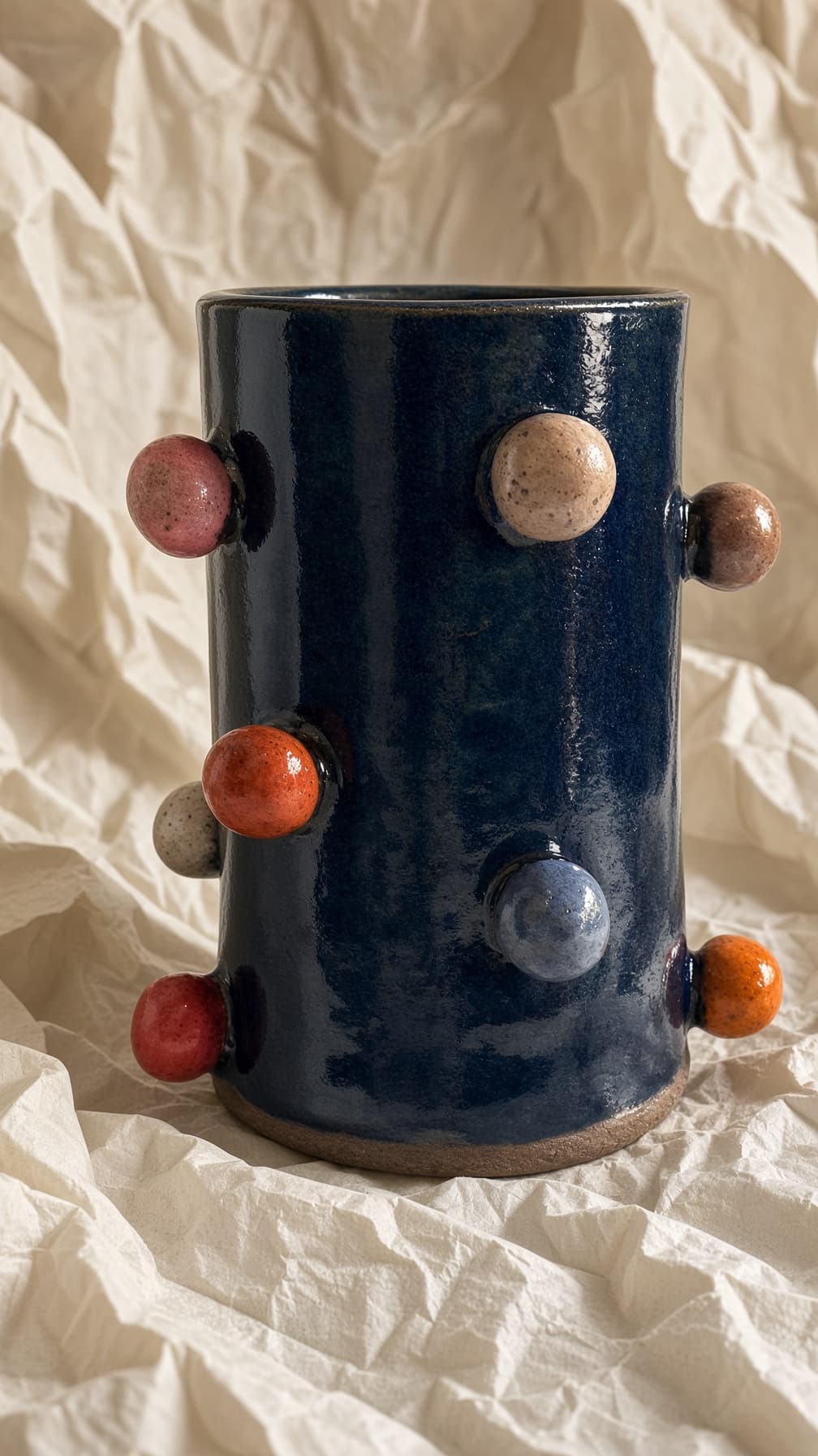 Vaso cilíndrico azul-marinho com bolinhas de esmalte colorido