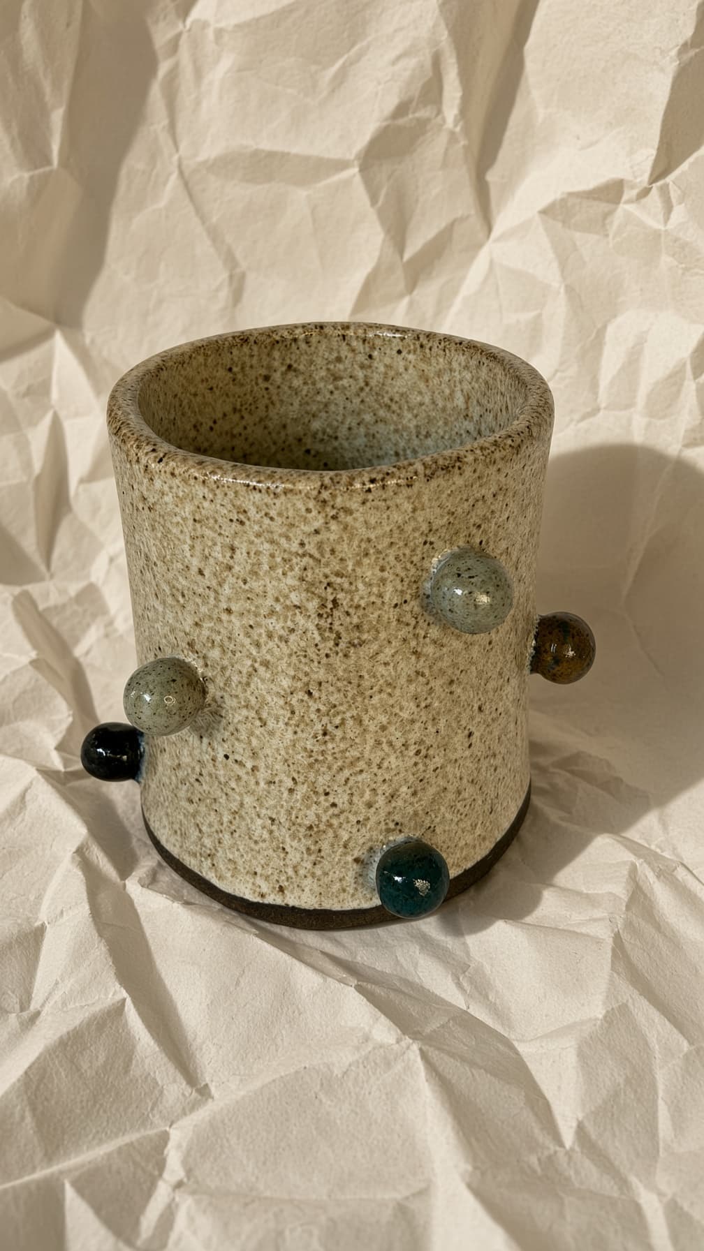 Vaso cilíndrico creme salpicado com bolinhas de esmalte