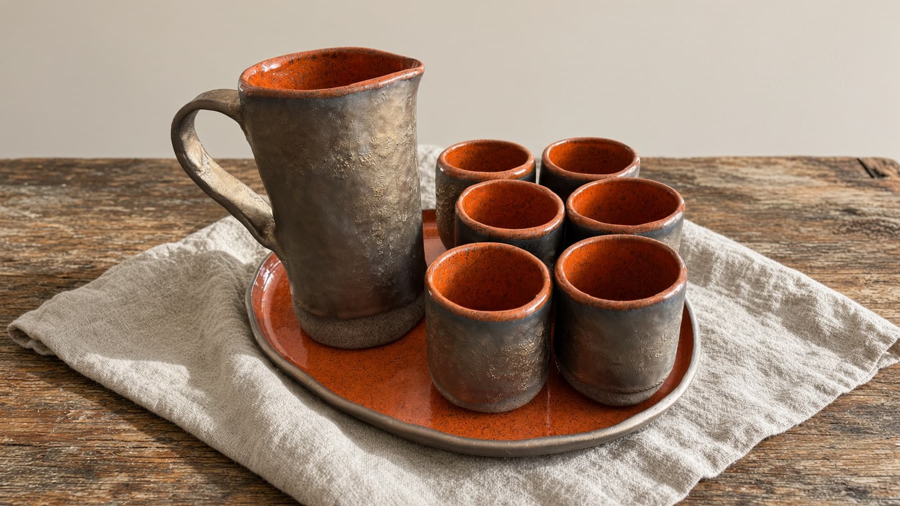 Jarra, seis copos e travessa oval em esmalte terracota e cinza
